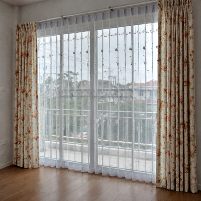 ผ้าม่านจีบลายดอกไม้ทึบคู่ผ้าม่านโปร่งติดตั้งบริเวณประตูกระจกบานใหญ่ เพิ่มความสว่างและความเป็นส่วนตัวให้ห้อง