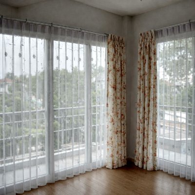 ผ้าม่านจีบลายดอกไม้ทึบ-โปร่งติดตั้งในมุมห้องกระจก ช่วยให้แสงธรรมชาติส่องผ่านและเพิ่มความอบอุ่นให้พื้นที่