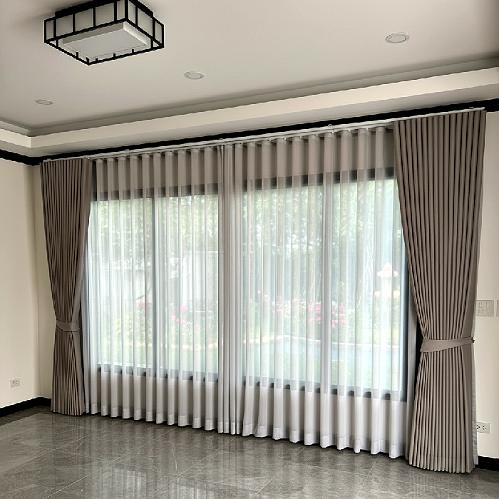 ผ้าม่านลอนสีโอวัลตินพร้อมผ้าโปร่งสีขาว ติดตั้งเต็มหน้าต่างห้องรับแขกบ้านเดี่ยว